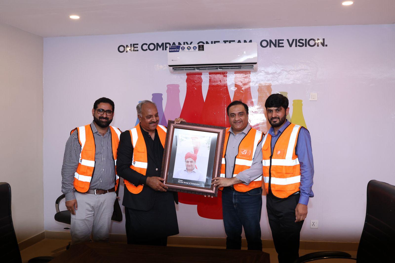 Barkat Corporation team presenting a framed photo gift at a company event